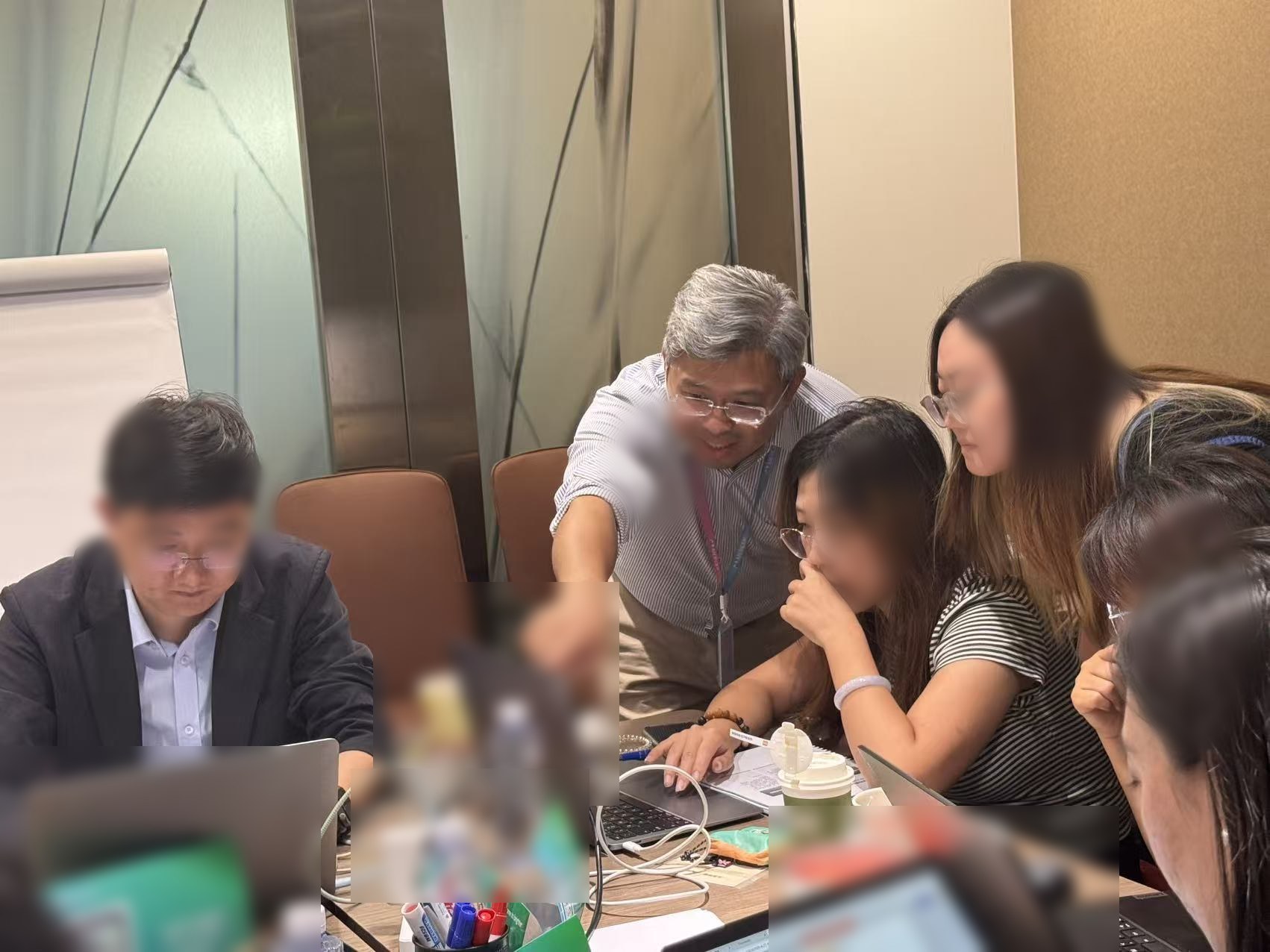 周俊东在工作坊现场俯身指导学员使用电脑完成 AI+HR 任务